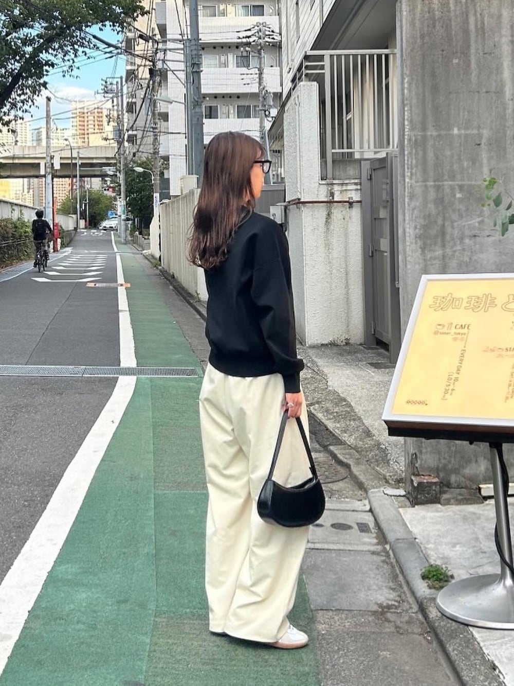 ブラック系のカーディガン/ボレロ、ブラック系のショルダーバッグ、ホワイト系のスニーカーを着用したレディースの秋コーディネートの4枚目の写真