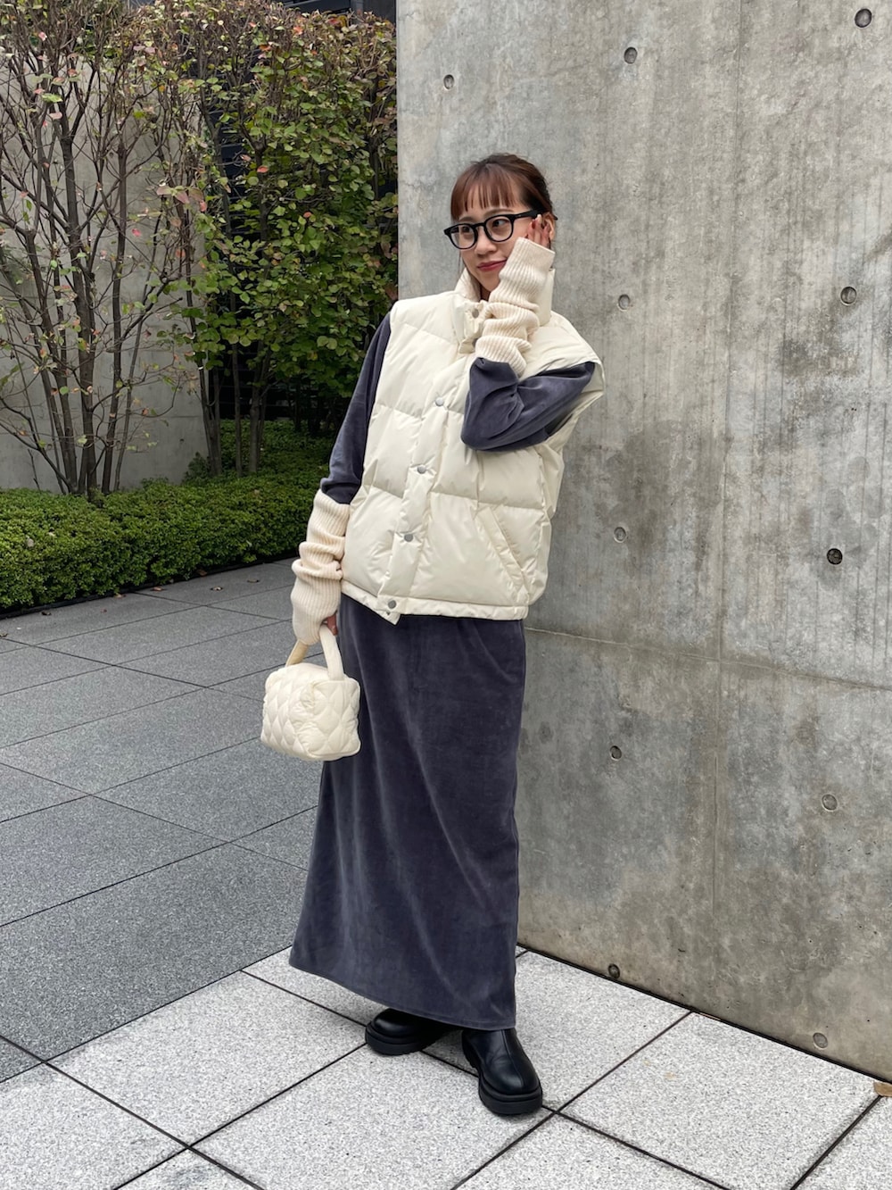 ブラック系のブーツ、ホワイト系のショルダーバッグ、ブラック系のメガネを着用したレディースの秋コーディネートの4枚目の写真