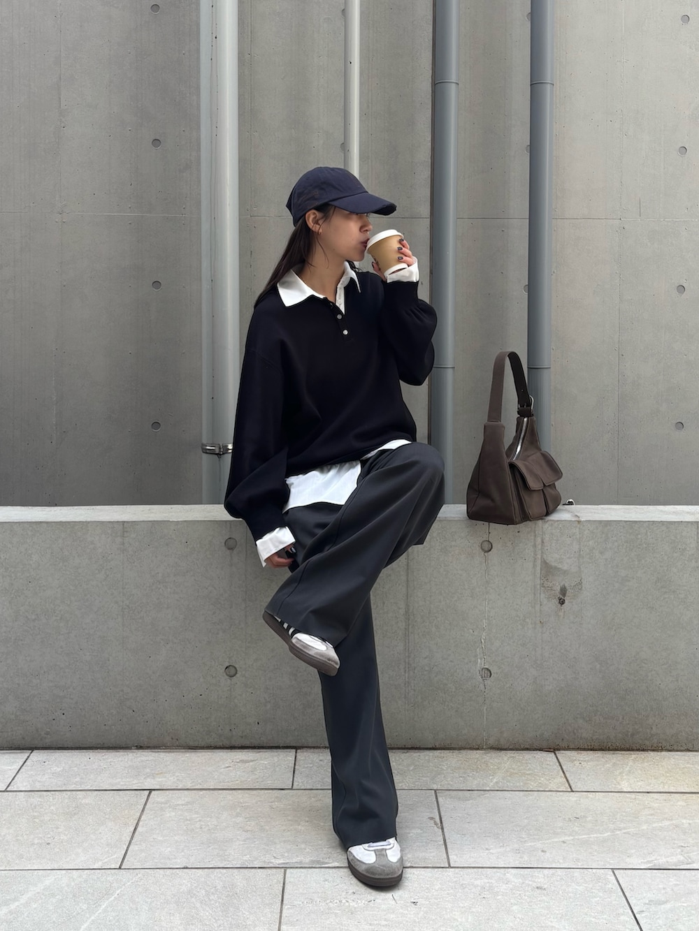 ブラック系のニット/セーター、グレー系のスラックス、ブラウン系のショルダーバッグを着用したレディースの冬コーディネートの2枚目の写真