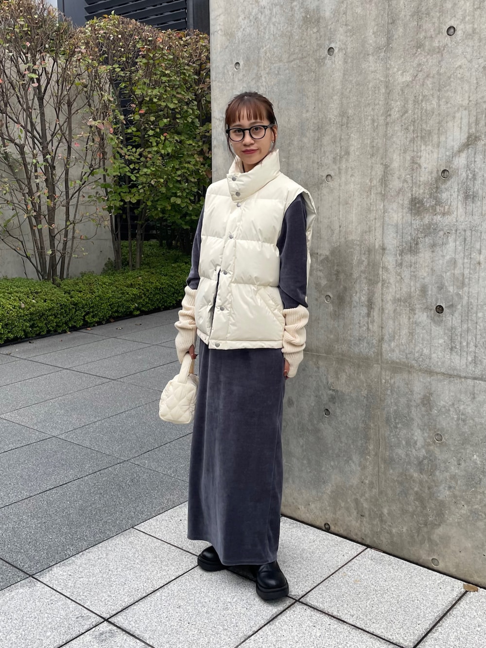 ブラック系のブーツ、ホワイト系のショルダーバッグ、ブラック系のメガネを着用したレディースの秋コーディネートの2枚目の写真