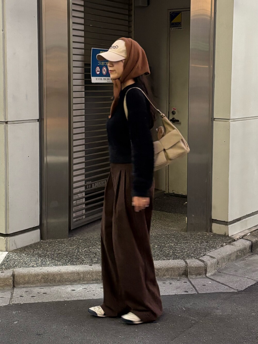 ブラック系のニット/セーター、ベージュ系のショルダーバッグ、ブラウン系のその他パンツを着用したレディースの秋コーディネートの2枚目の写真