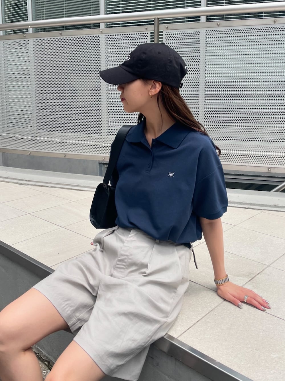 ブルー系のポロシャツ、ベージュ系のその他パンツ、ブラック系のスニーカーを着用したレディースの夏コーディネートの5枚目の写真