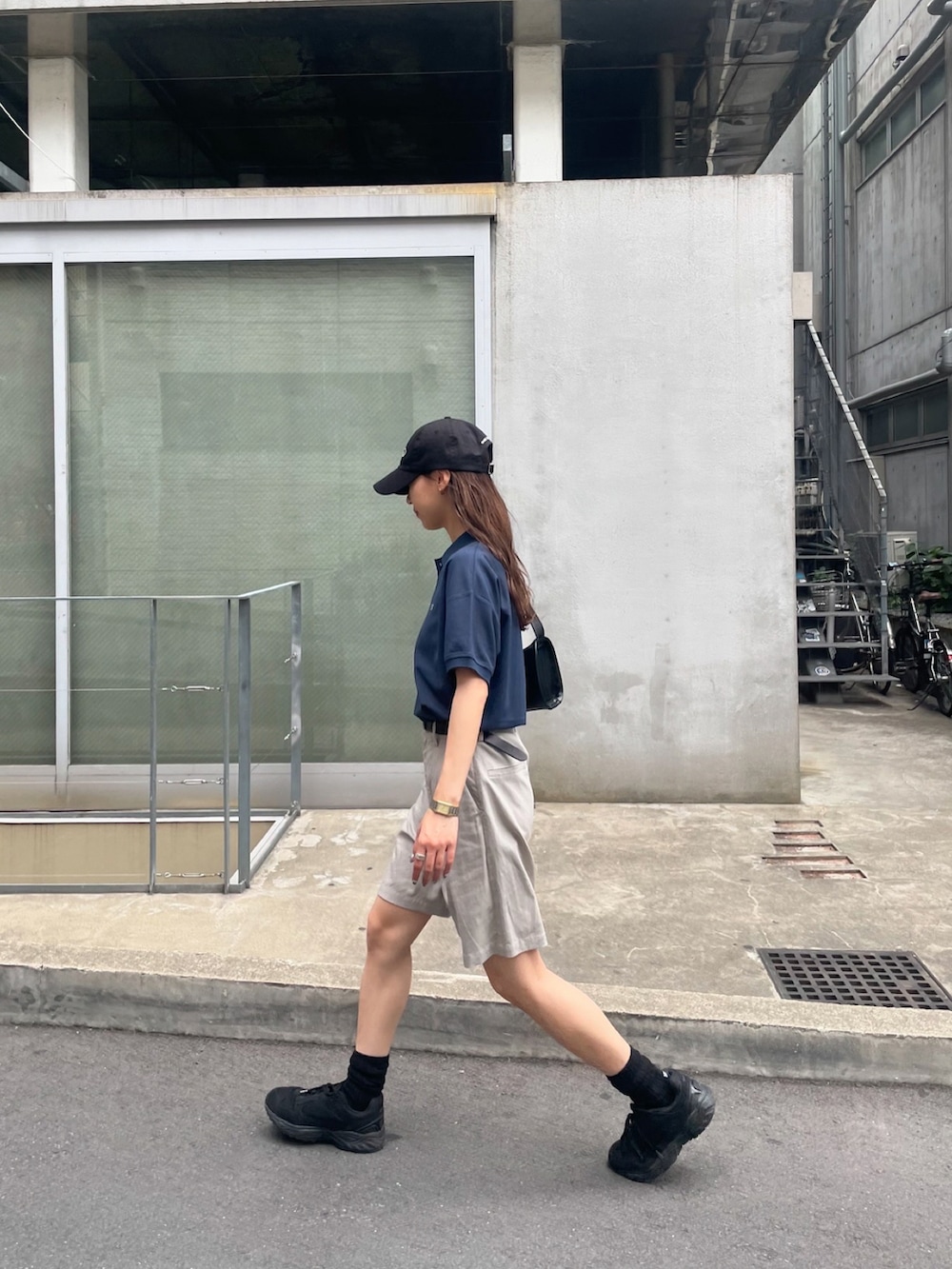 ブルー系のポロシャツ、ベージュ系のその他パンツ、ブラック系のスニーカーを着用したレディースの夏コーディネートの4枚目の写真