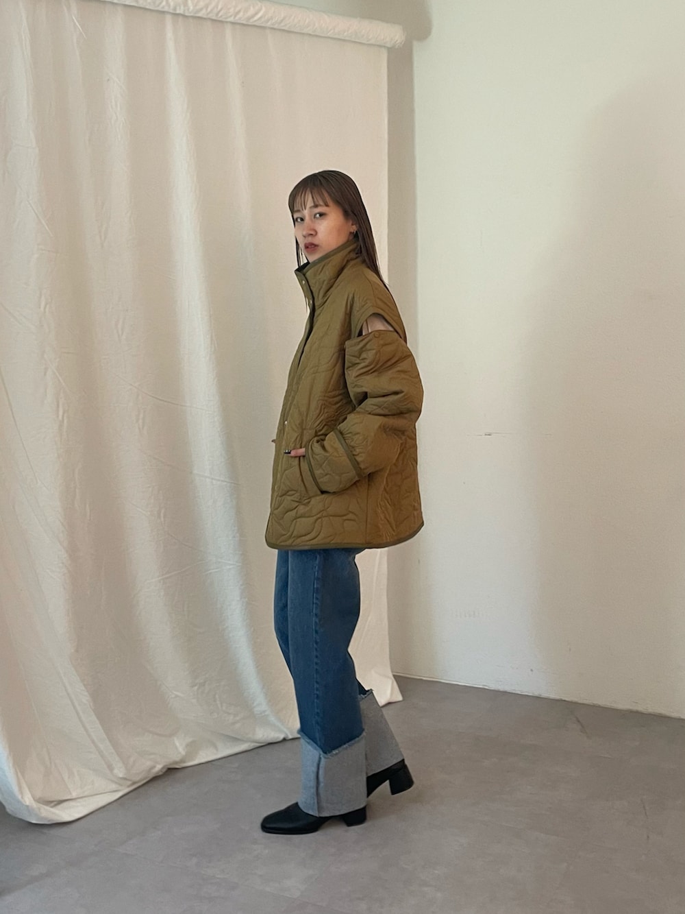 ブルー系のデニムパンツ、グリーン系のブルゾン、ブラック系のブーツを着用したレディースの夏コーディネートの3枚目の写真