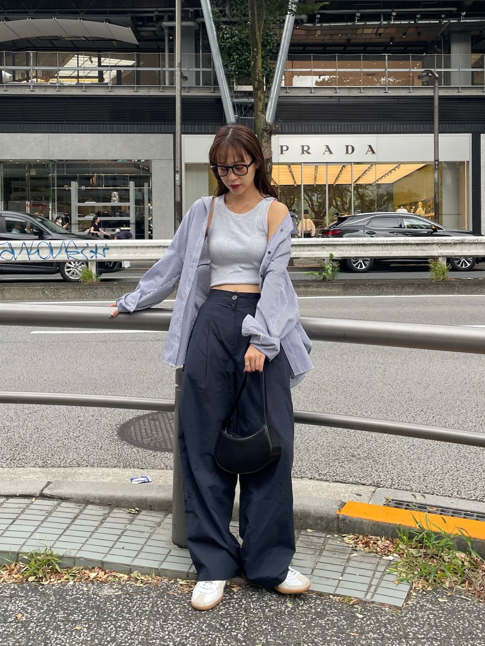 ブラック系のショルダーバッグ、ブルー系のその他パンツ、ホワイト系のスニーカーを着用したレディースの秋コーディネートの4枚目の写真