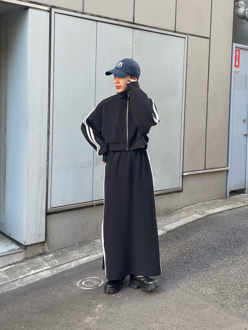 ブラック系のスカート、ブラック系のブーツ、ブラック系のジャケット/アウターを着用したレディースの夏コーディネートの4枚目の写真