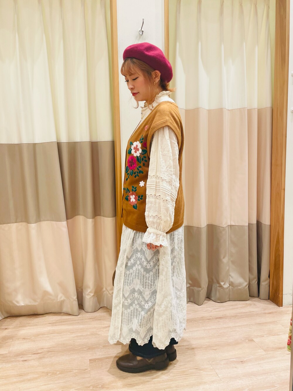 イエロー系のベスト、ホワイト系のシャツ/ブラウス、ブラウン系のハンドバッグを着用したレディースの秋コーディネートの4枚目の写真