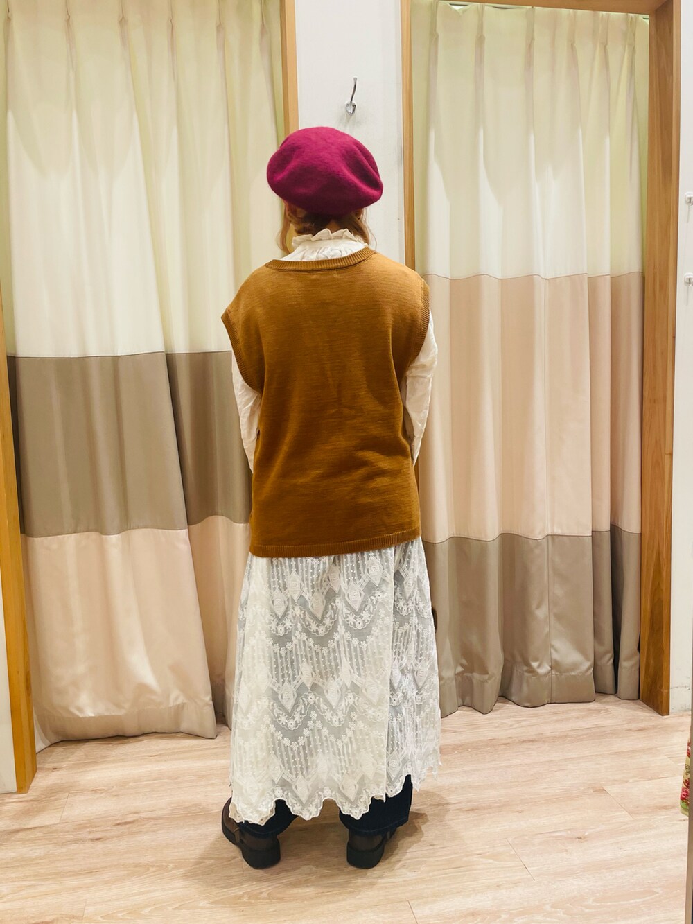 イエロー系のベスト、ホワイト系のシャツ/ブラウス、ブラウン系のハンドバッグを着用したレディースの秋コーディネートの5枚目の写真