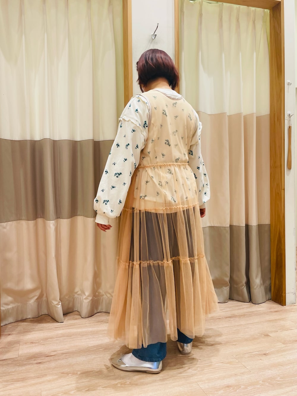 グリーン系のTシャツ/カットソー、オレンジ系のワンピース、ブルー系のデニムパンツを着用したレディースの春コーディネートの5枚目の写真