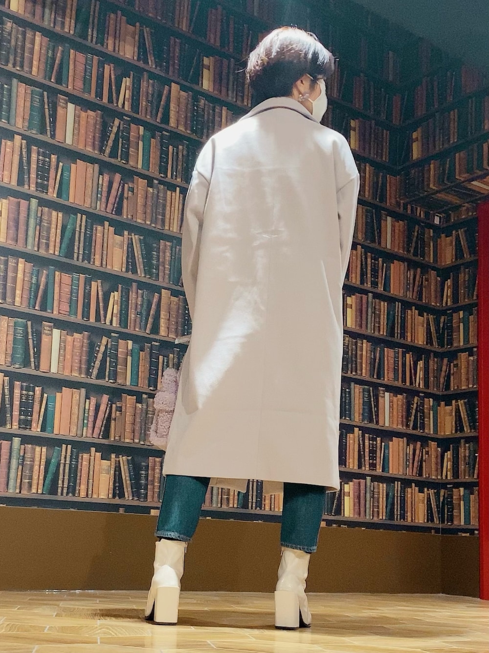 ホワイト系のニット/セーター、ブルー系のデニムパンツ、ホワイト系のブーツを着用したレディースの冬コーディネートの2枚目の写真