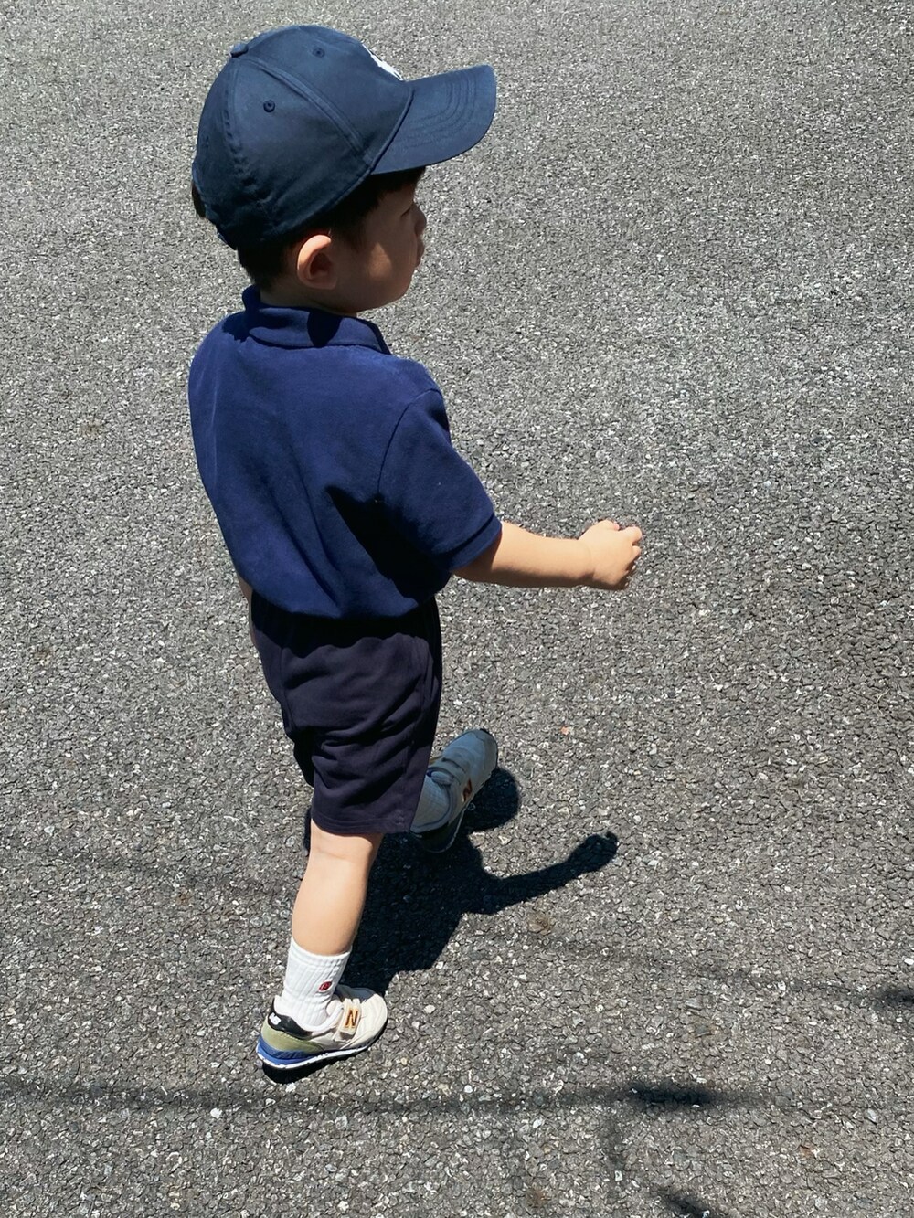 ブルー系のポロシャツ、ブルー系のパンツ、ベージュ系のスニーカーを着用したキッズの夏コーディネートの2枚目の写真