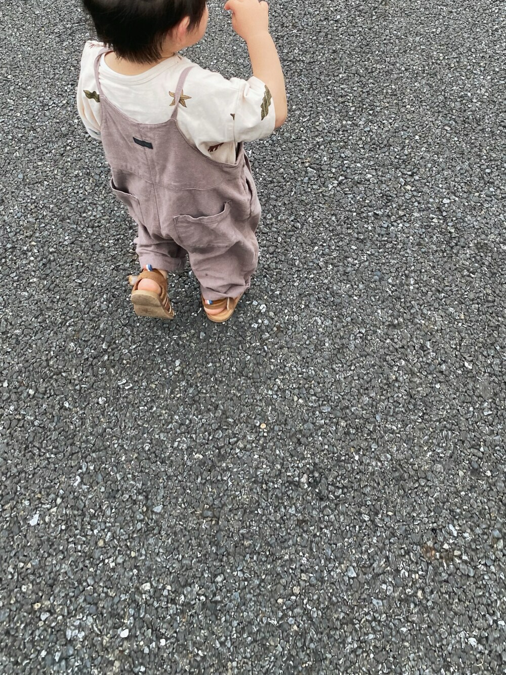 グレー系のオールインワン・サロペット、ブラウン系のサンダル、ホワイト系のTシャツ/カットソーを着用したキッズの夏コーディネートの2枚目の写真