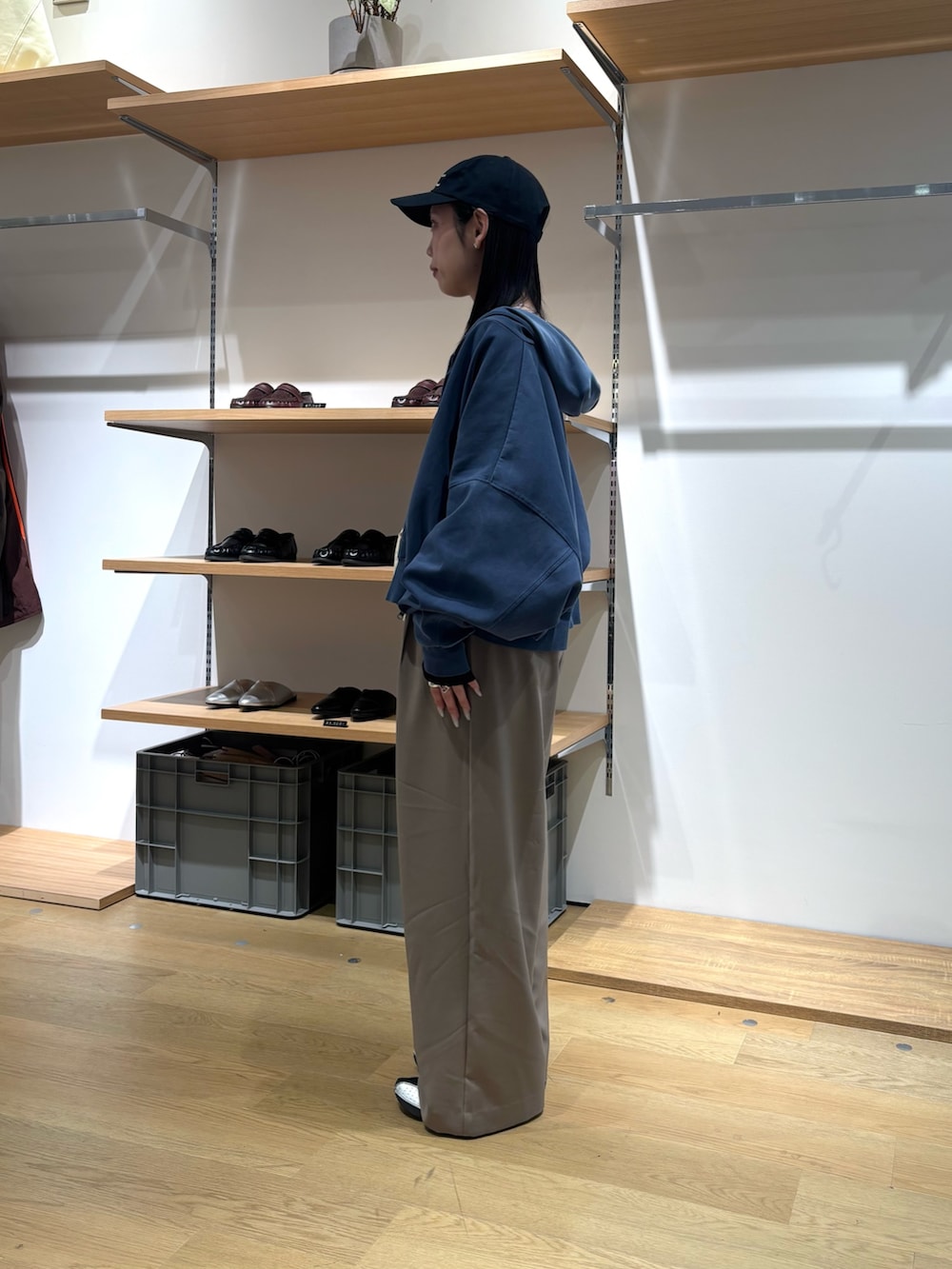 ブルー系のパーカー、ブラック系のTシャツ/カットソー、ベージュ系のスラックスを着用したレディースの春コーディネートの3枚目の写真