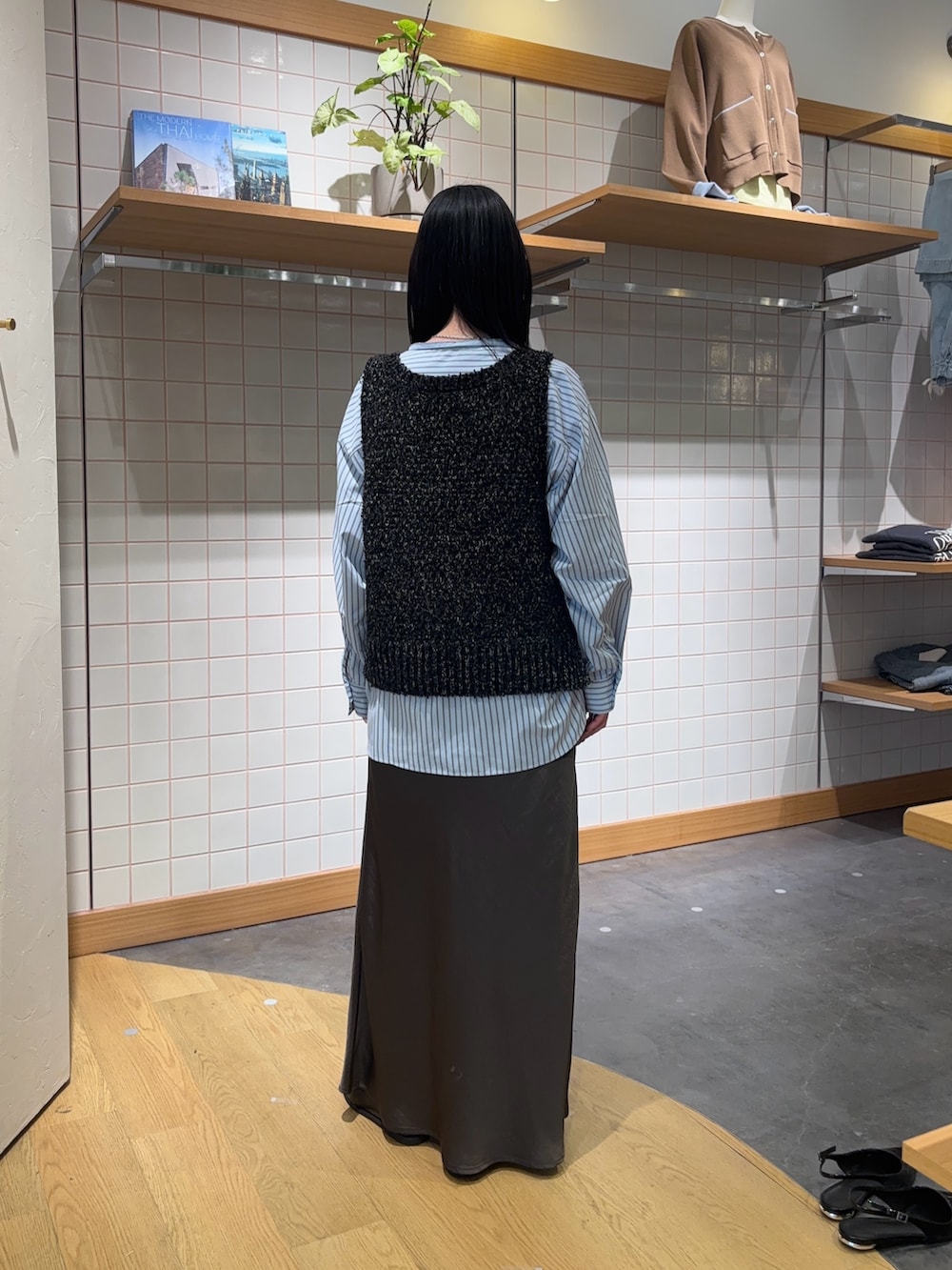 ブルー系のシャツ/ブラウス、ブラック系のベスト、グレー系のスカートを着用したレディースの春コーディネートの2枚目の写真