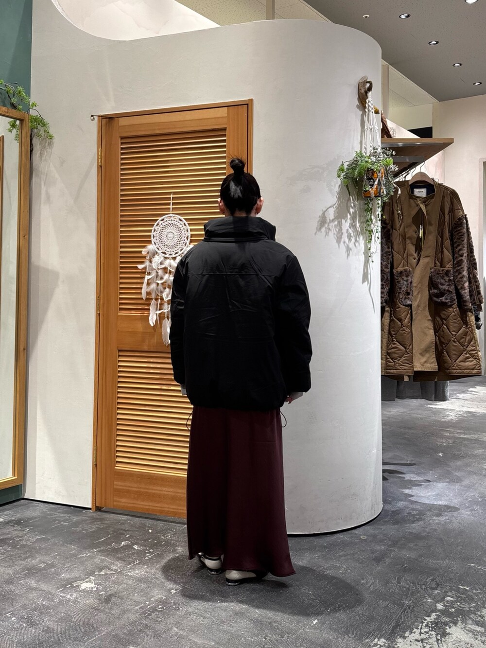 ブラック系のダウンジャケット/コート、グレー系のニット/セーター、レッド系のスカートを着用したレディースの冬コーディネートの4枚目の写真