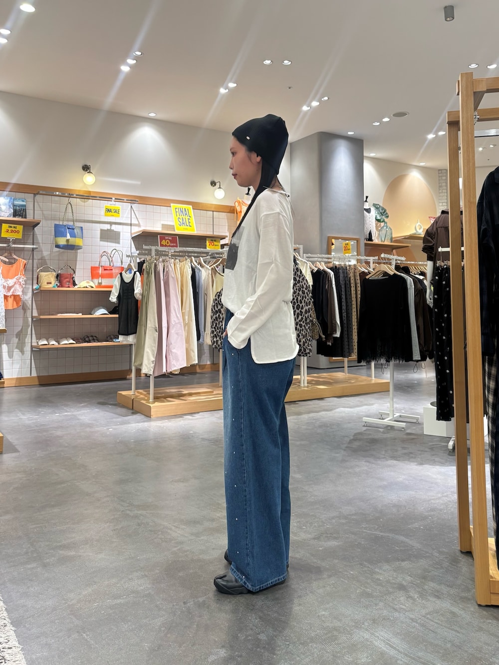 ホワイト系のTシャツ/カットソー、ブラウン系のショルダーバッグ、ブルー系のデニムパンツを着用したレディースの秋コーディネートの2枚目の写真