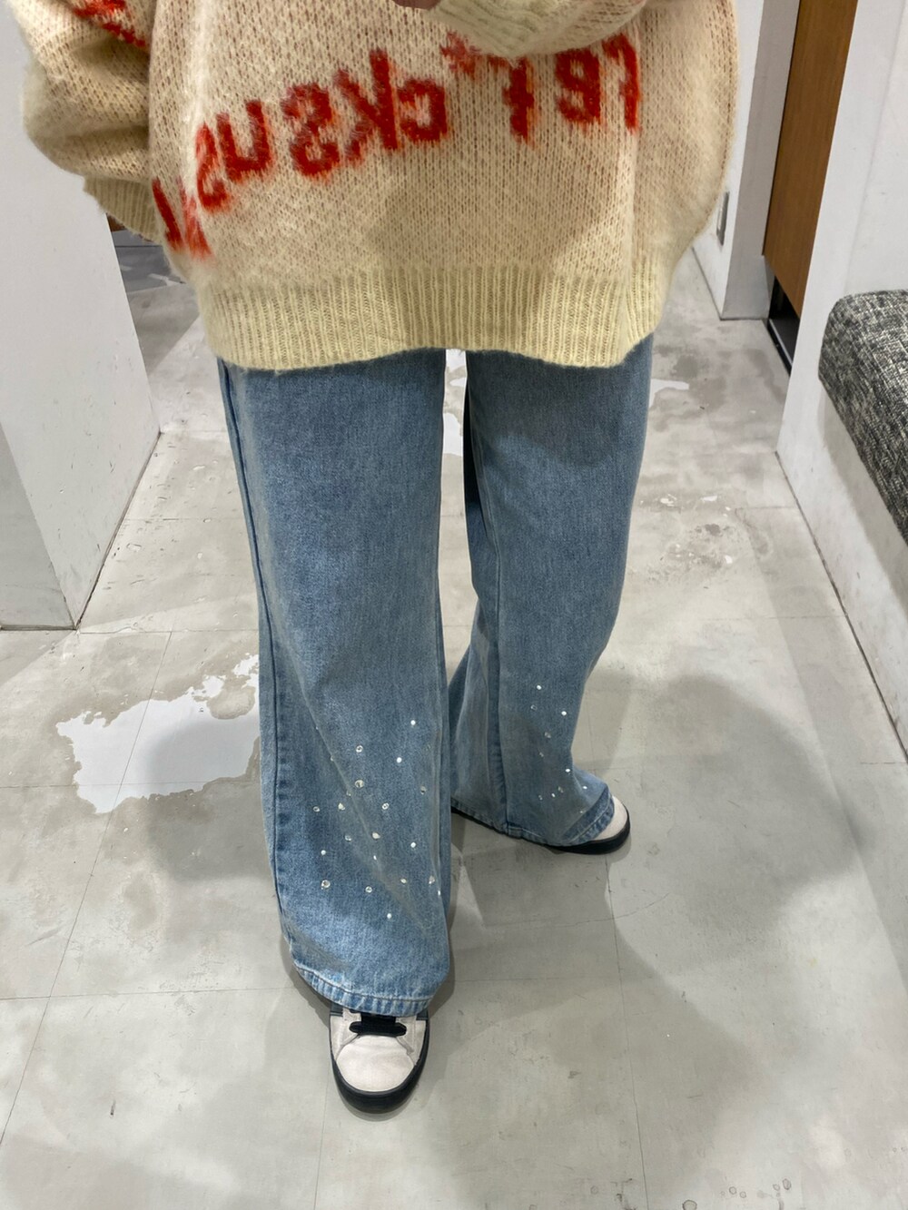 ホワイト系のニット/セーター、ブルー系のデニムパンツを着用したレディースの冬コーディネートの4枚目の写真