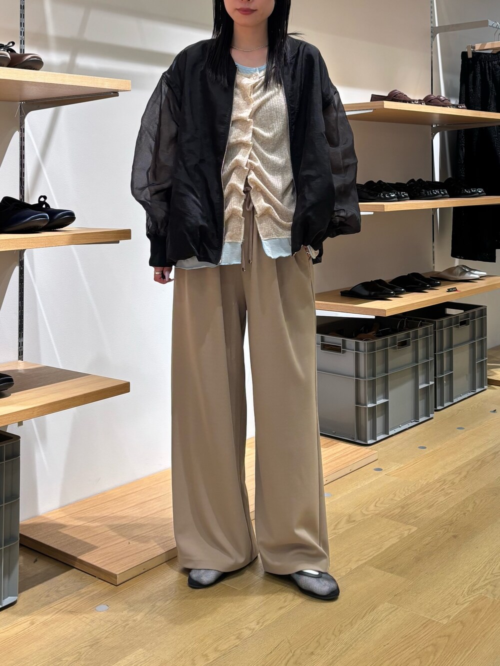 ブラック系のブルゾン、ベージュ系のカーディガン/ボレロ、ベージュ系のスラックスを着用したレディースの春コーディネートの8枚目の写真