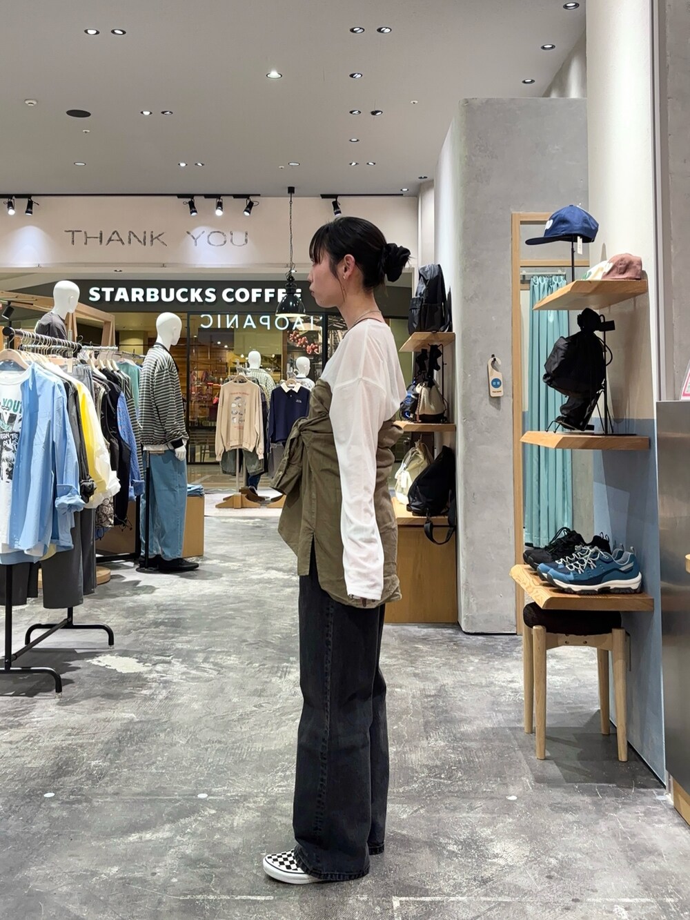 ホワイト系のTシャツ/カットソー、グリーン系のシャツ/ブラウス、ブラック系のデニムパンツを着用したレディースの春コーディネートの2枚目の写真