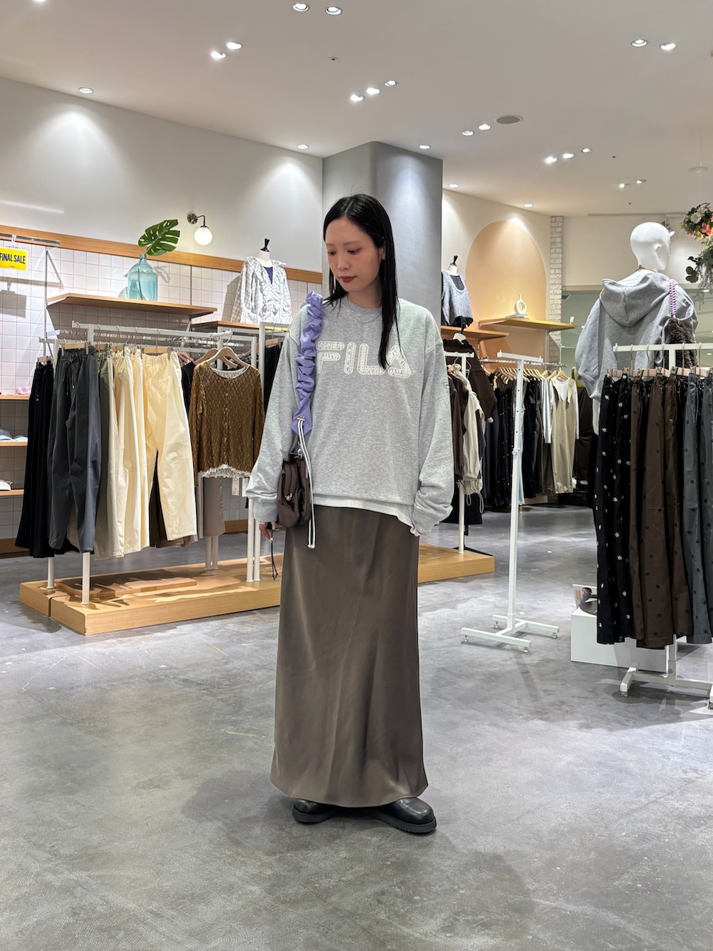 グレー系のスウェット、ホワイト系のTシャツ/カットソー、グレー系のスカートを着用したレディースの秋コーディネートの3枚目の写真