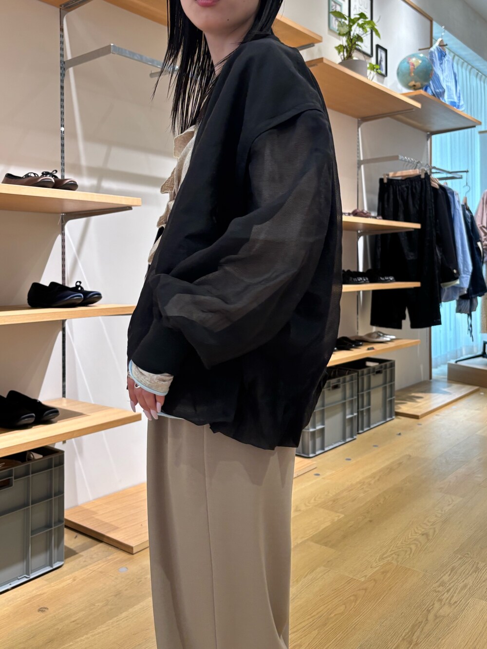 ブラック系のブルゾン、ベージュ系のカーディガン/ボレロ、ベージュ系のスラックスを着用したレディースの春コーディネートの6枚目の写真