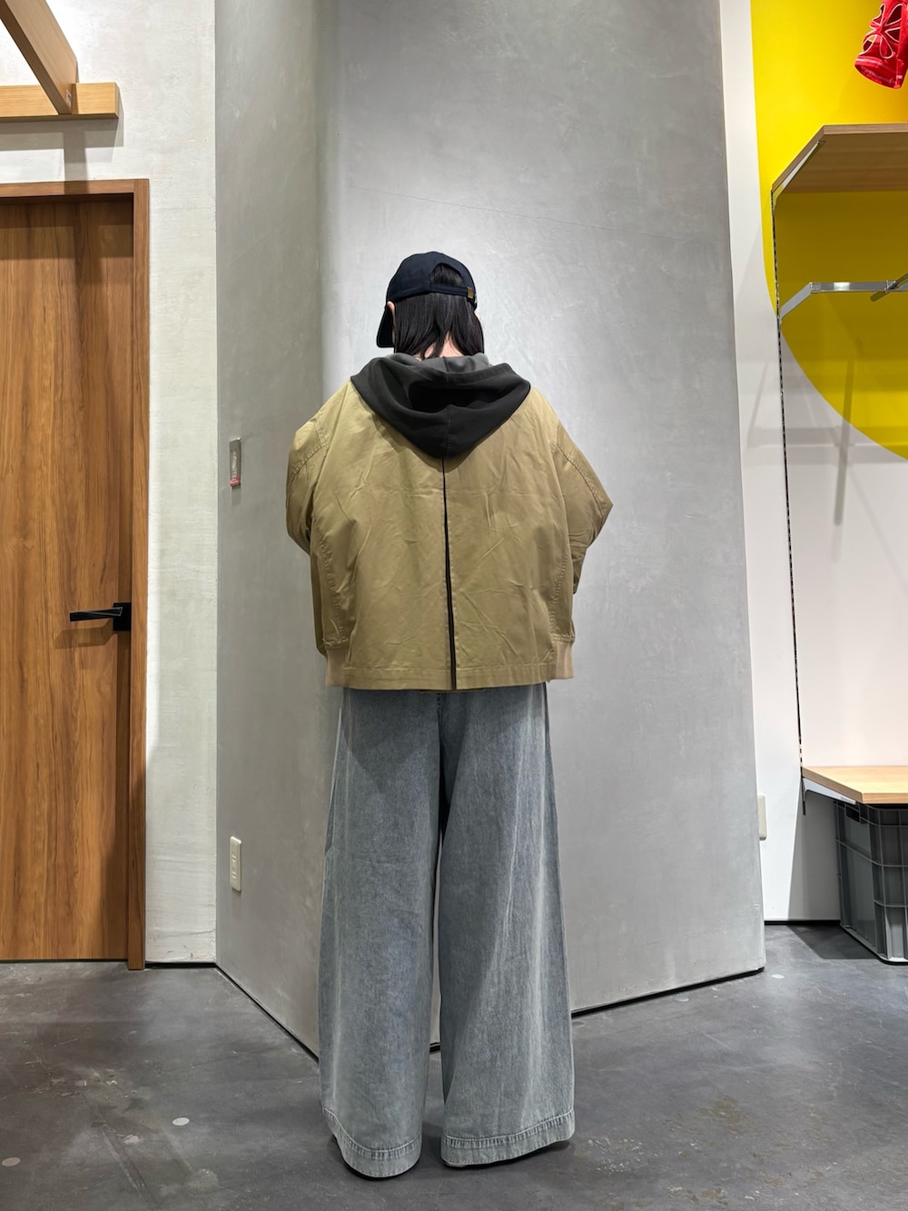 ベージュ系のトレンチコート、グレー系のパーカー、ブルー系のデニムパンツを着用したレディースの春コーディネートの2枚目の写真