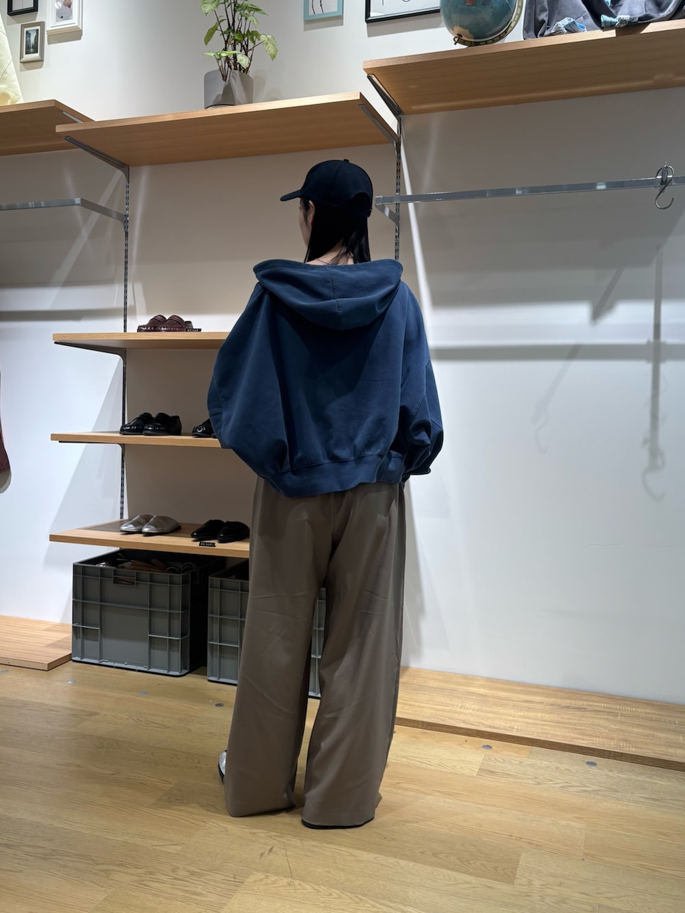 ブルー系のパーカー、ブラック系のTシャツ/カットソー、ベージュ系のスラックスを着用したレディースの春コーディネートの4枚目の写真