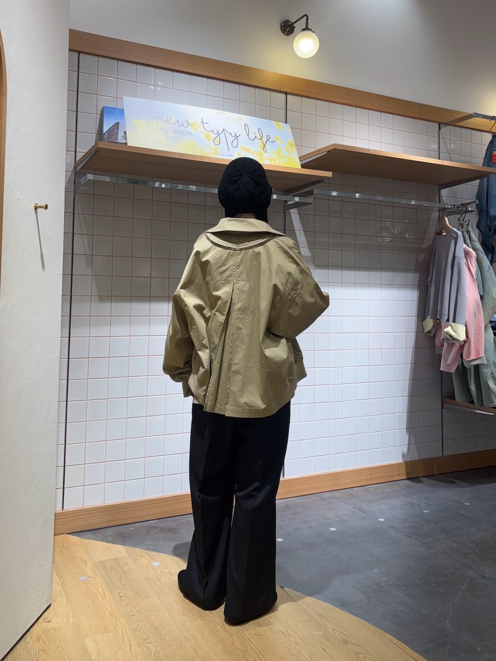 ベージュ系のトレンチコート、ホワイト系のTシャツ/カットソー、ブラック系のサロペット/オーバーオールを着用したレディースの春コーディネートの2枚目の写真