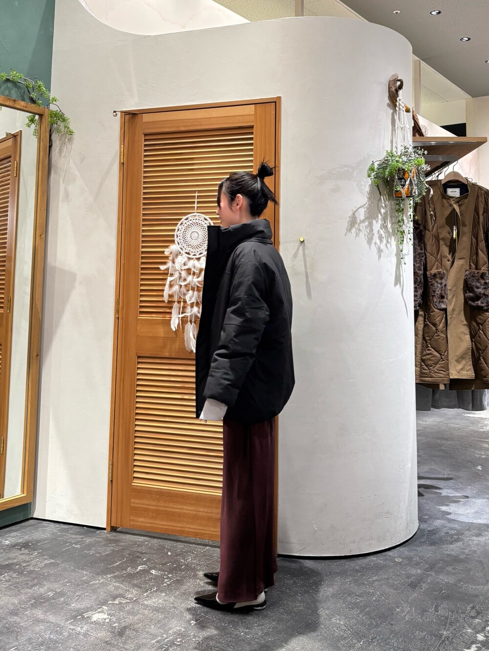 ブラック系のダウンジャケット/コート、グレー系のニット/セーター、レッド系のスカートを着用したレディースの冬コーディネートの3枚目の写真