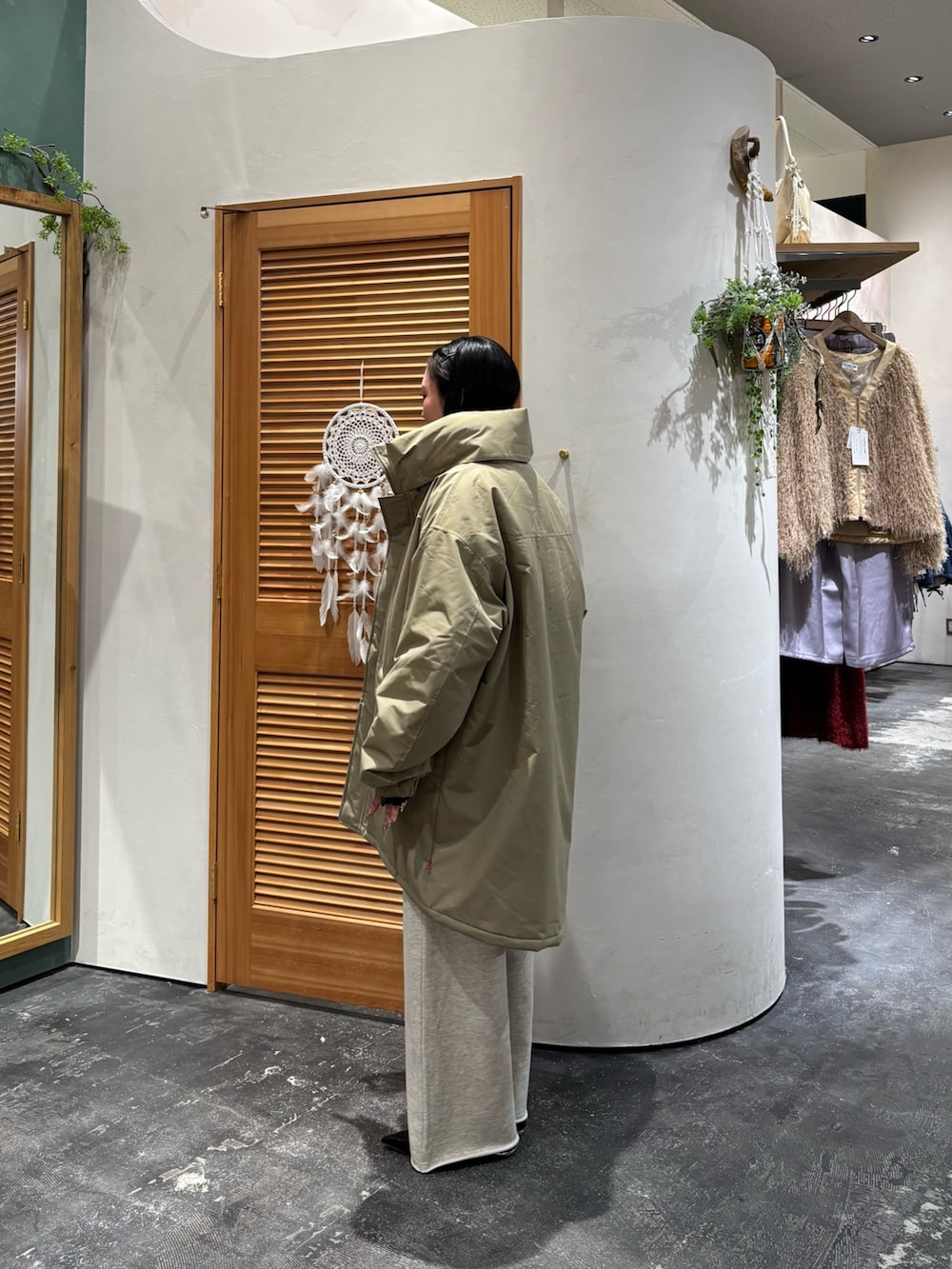 ベージュ系のダウンジャケット/コート、ブラウン系のニット/セーター、ホワイト系のスウェットパンツを着用したレディースの冬コーディネートの3枚目の写真