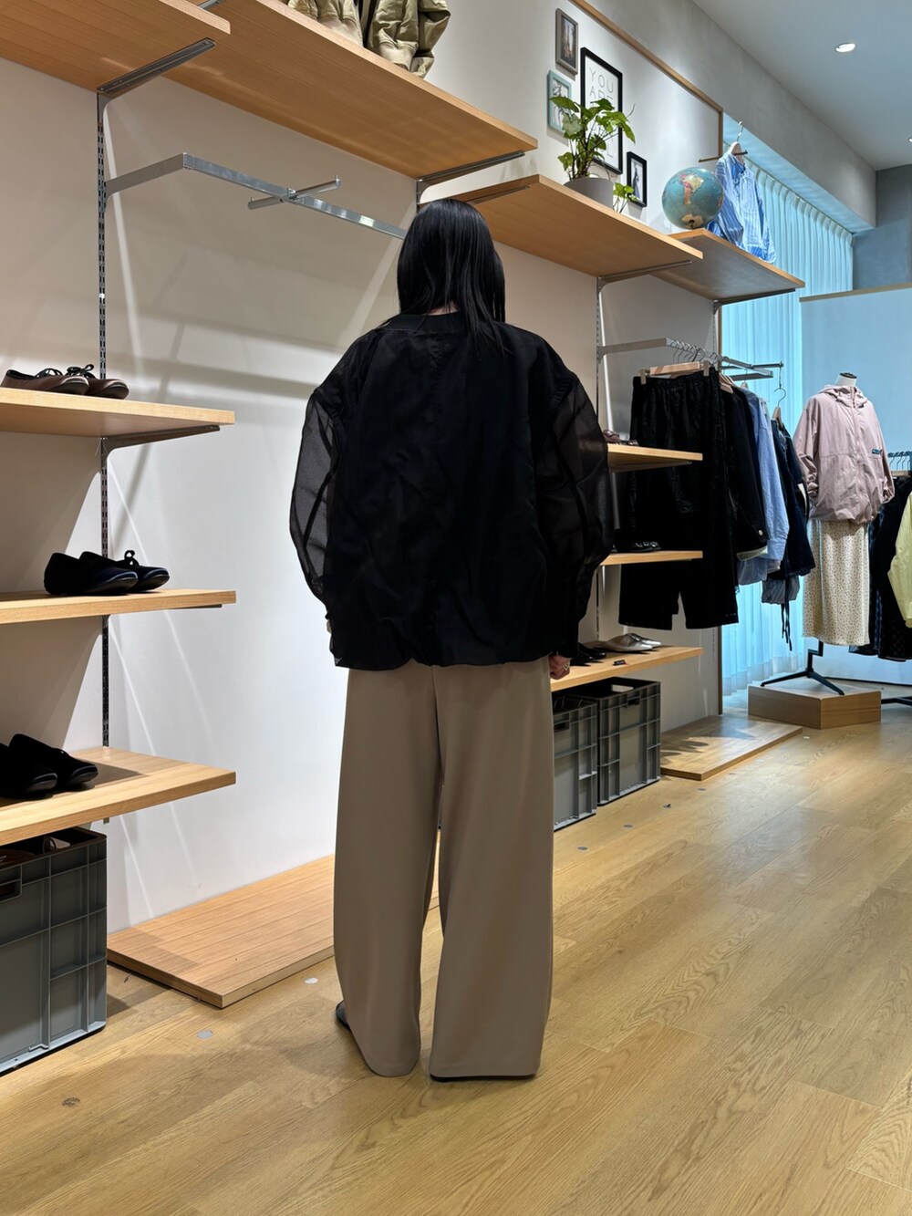 ブラック系のブルゾン、ベージュ系のカーディガン/ボレロ、ベージュ系のスラックスを着用したレディースの春コーディネートの4枚目の写真