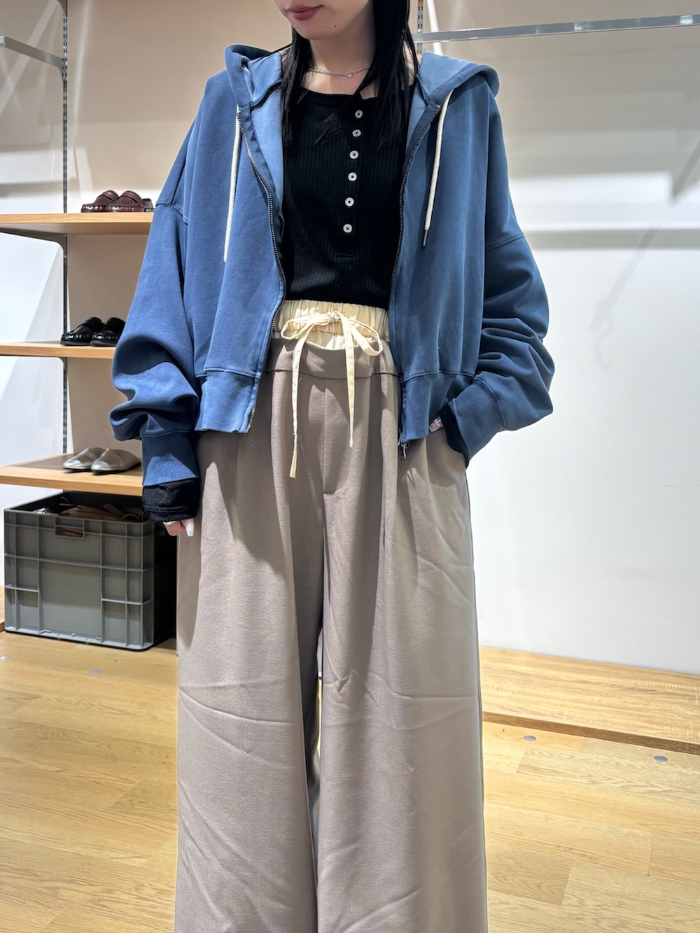 ブルー系のパーカー、ブラック系のTシャツ/カットソー、ベージュ系のスラックスを着用したレディースの春コーディネートの6枚目の写真