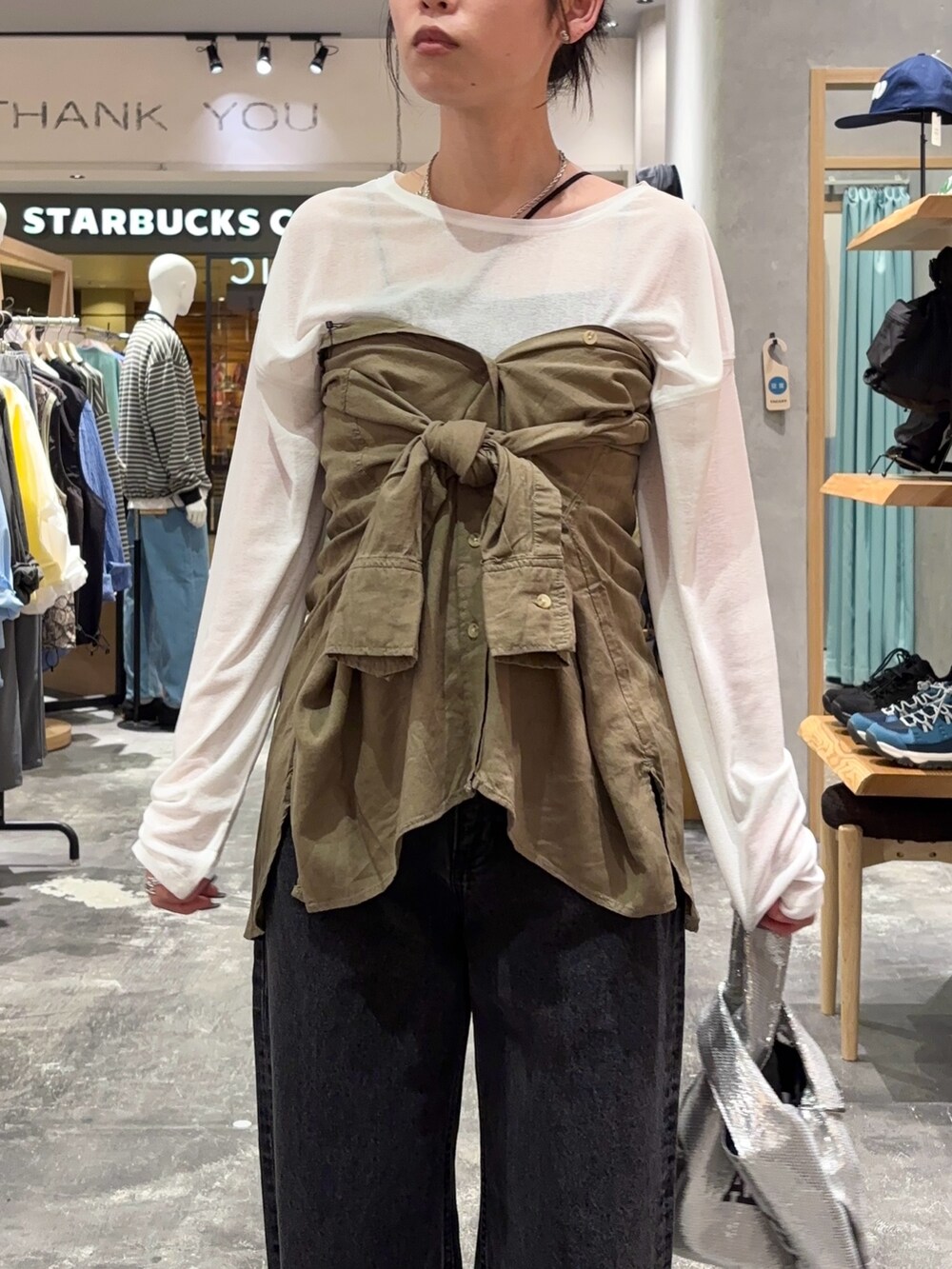 ホワイト系のTシャツ/カットソー、グリーン系のシャツ/ブラウス、ブラック系のデニムパンツを着用したレディースの春コーディネートの4枚目の写真