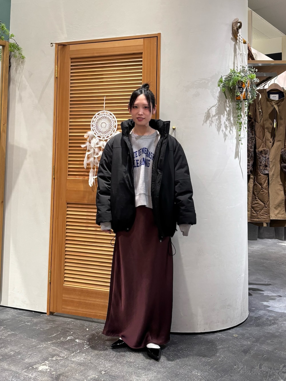 ブラック系のダウンジャケット/コート、グレー系のニット/セーター、レッド系のスカートを着用したレディースの冬コーディネートの2枚目の写真