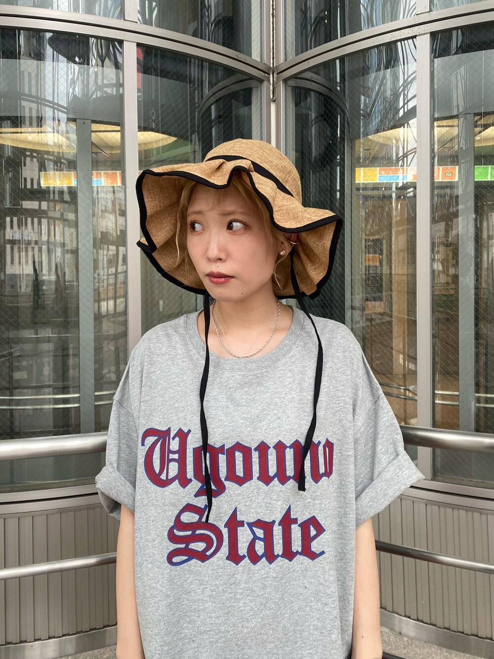 レッド系のスカート、グレー系のTシャツ/カットソー、ブラック系のハットを着用したレディースの夏コーディネートの2枚目の写真