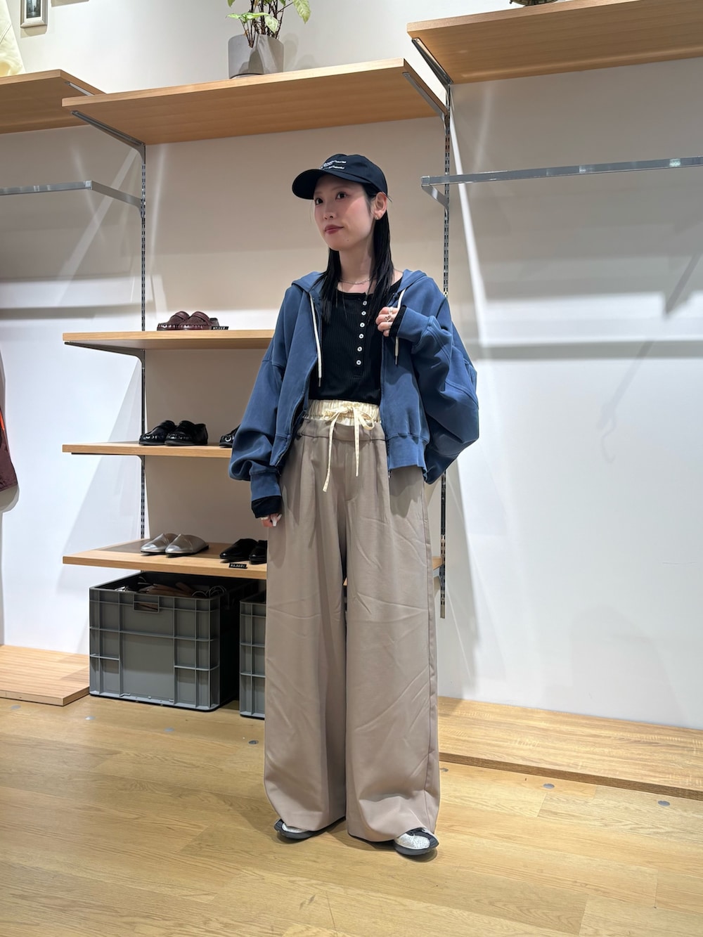 ブルー系のパーカー、ブラック系のTシャツ/カットソー、ベージュ系のスラックスを着用したレディースの春コーディネートの2枚目の写真