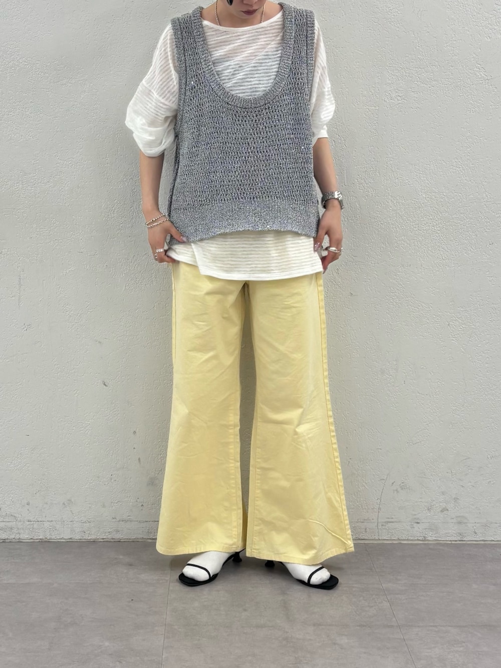 グレー系のベスト、ホワイト系のTシャツ/カットソー、イエロー系のデニムパンツを着用したレディースの春コーディネートの5枚目の写真