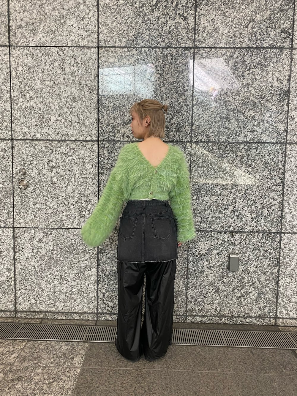 グリーン系のカーディガン/ボレロ、ブラック系のデニムスカート、ブラック系のカーゴパンツを着用したレディースの秋コーディネートの2枚目の写真