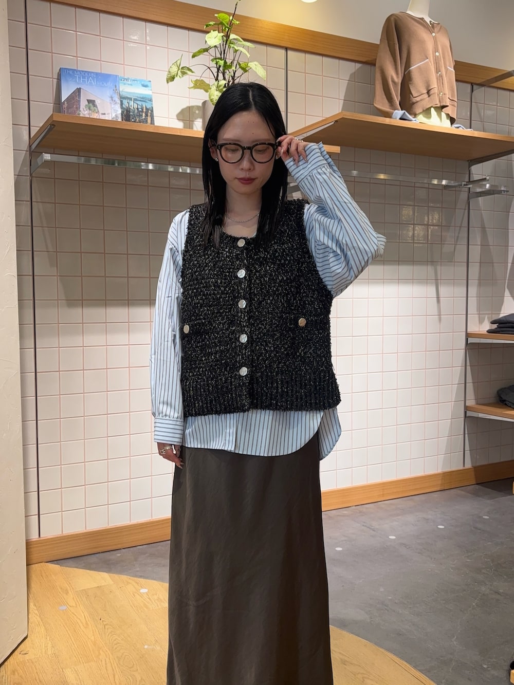 ブルー系のシャツ/ブラウス、ブラック系のベスト、グレー系のスカートを着用したレディースの春コーディネートの4枚目の写真