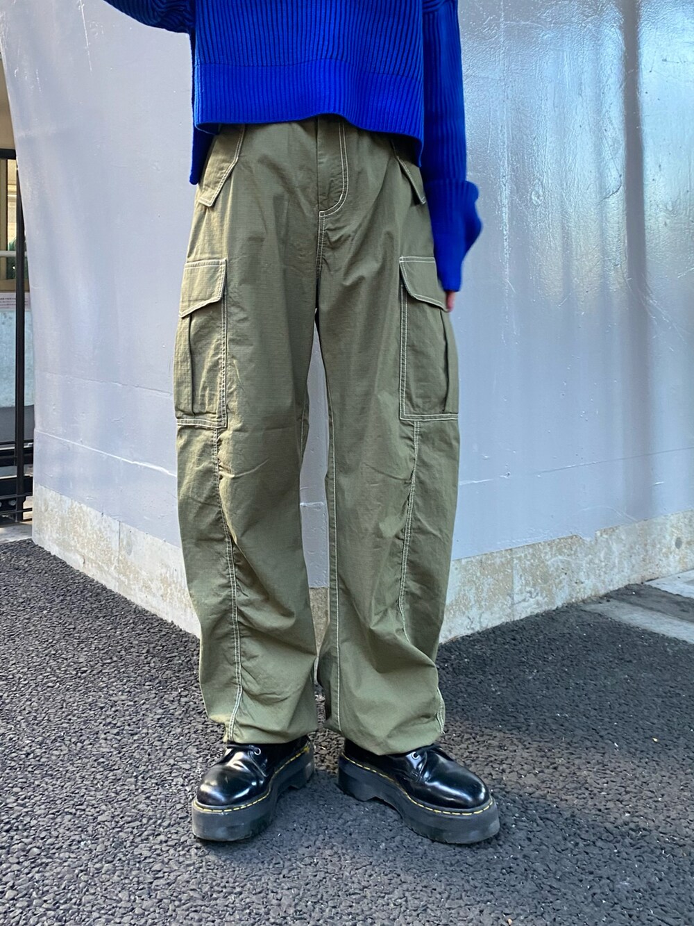 ブルー系のニット/セーター、グリーン系のカーゴパンツを着用したレディースの秋コーディネートの4枚目の写真