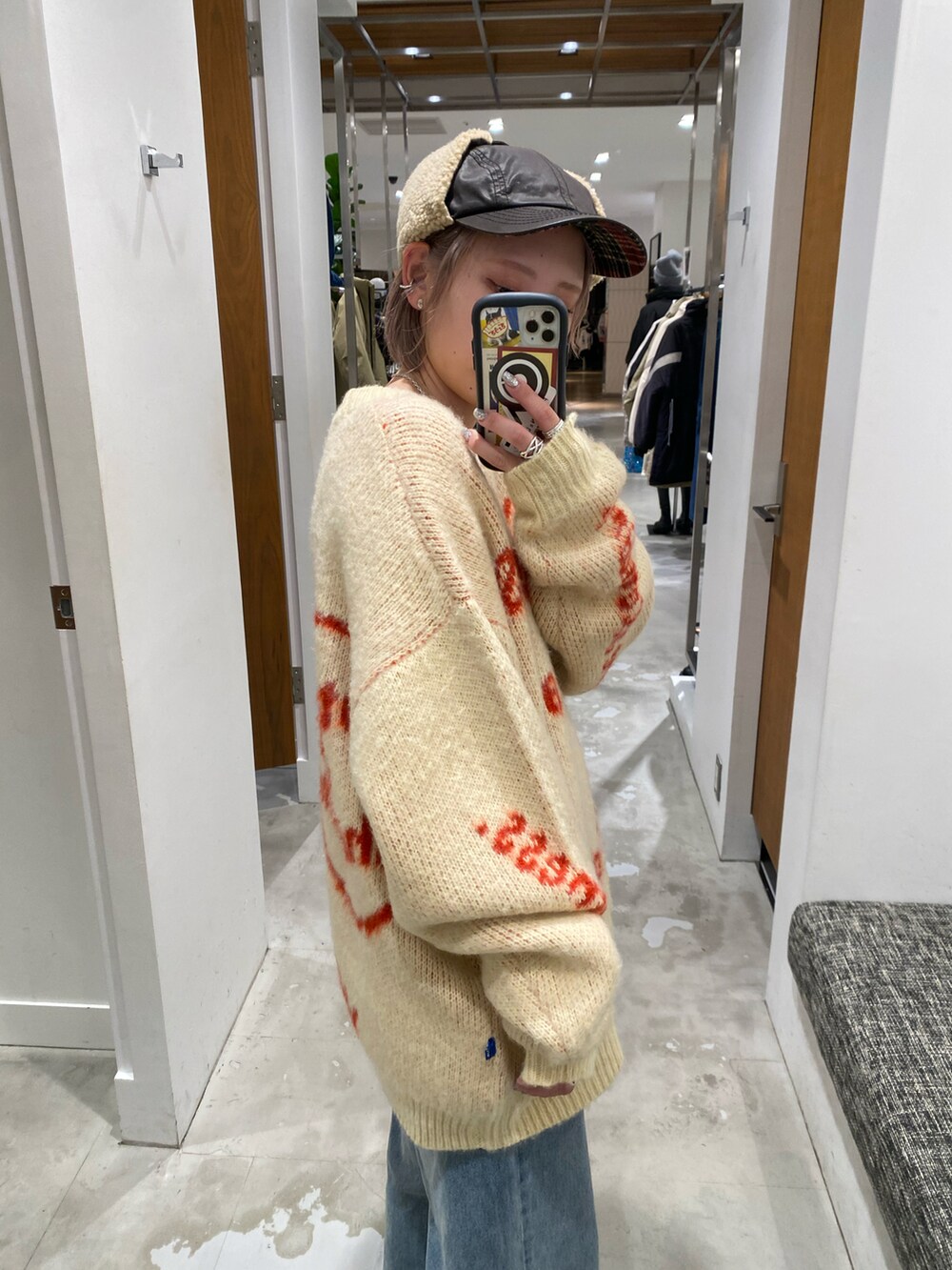 ホワイト系のニット/セーター、ブルー系のデニムパンツを着用したレディースの冬コーディネートの3枚目の写真