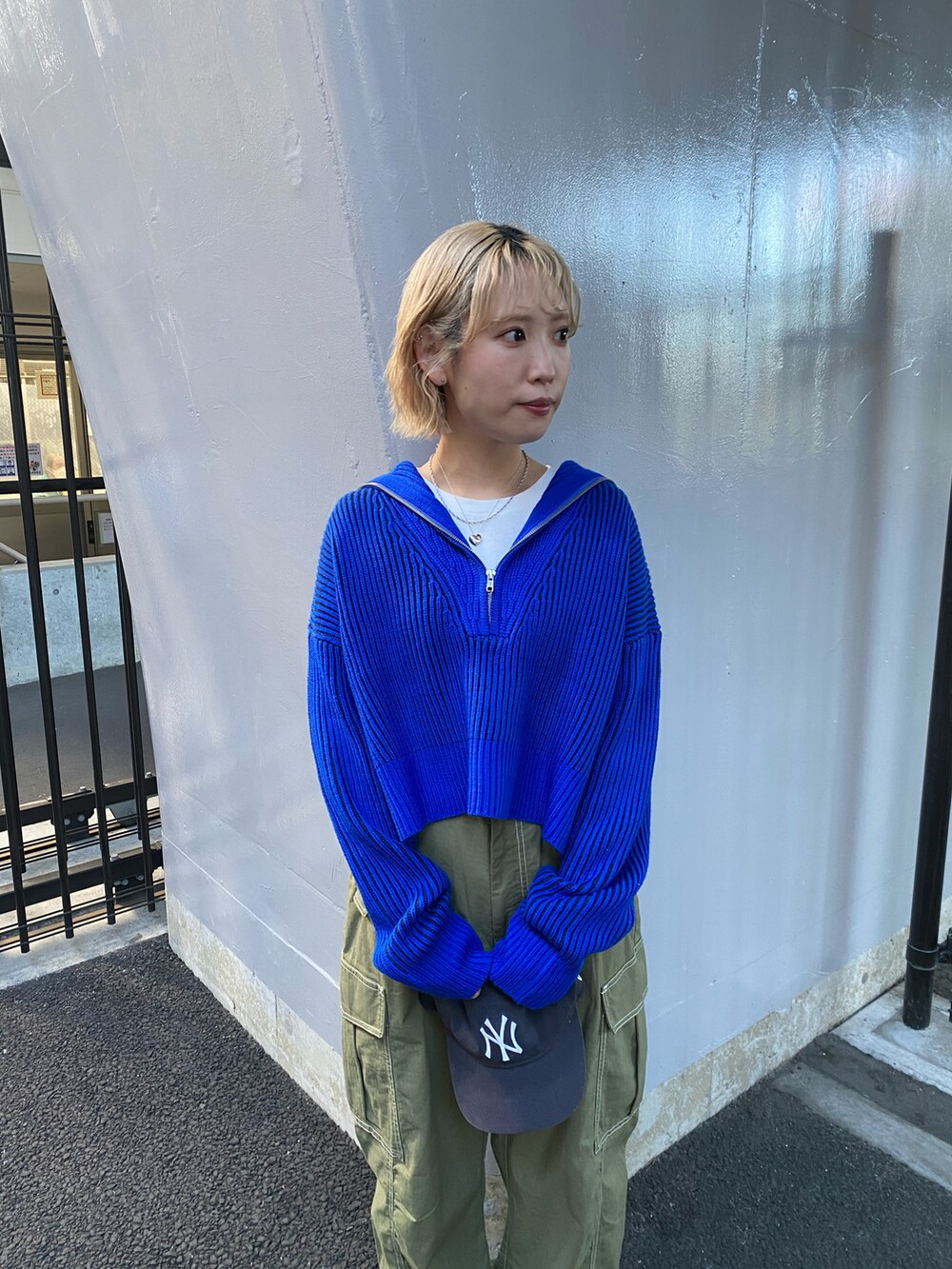 ブルー系のニット/セーター、グリーン系のカーゴパンツを着用したレディースの秋コーディネートの2枚目の写真