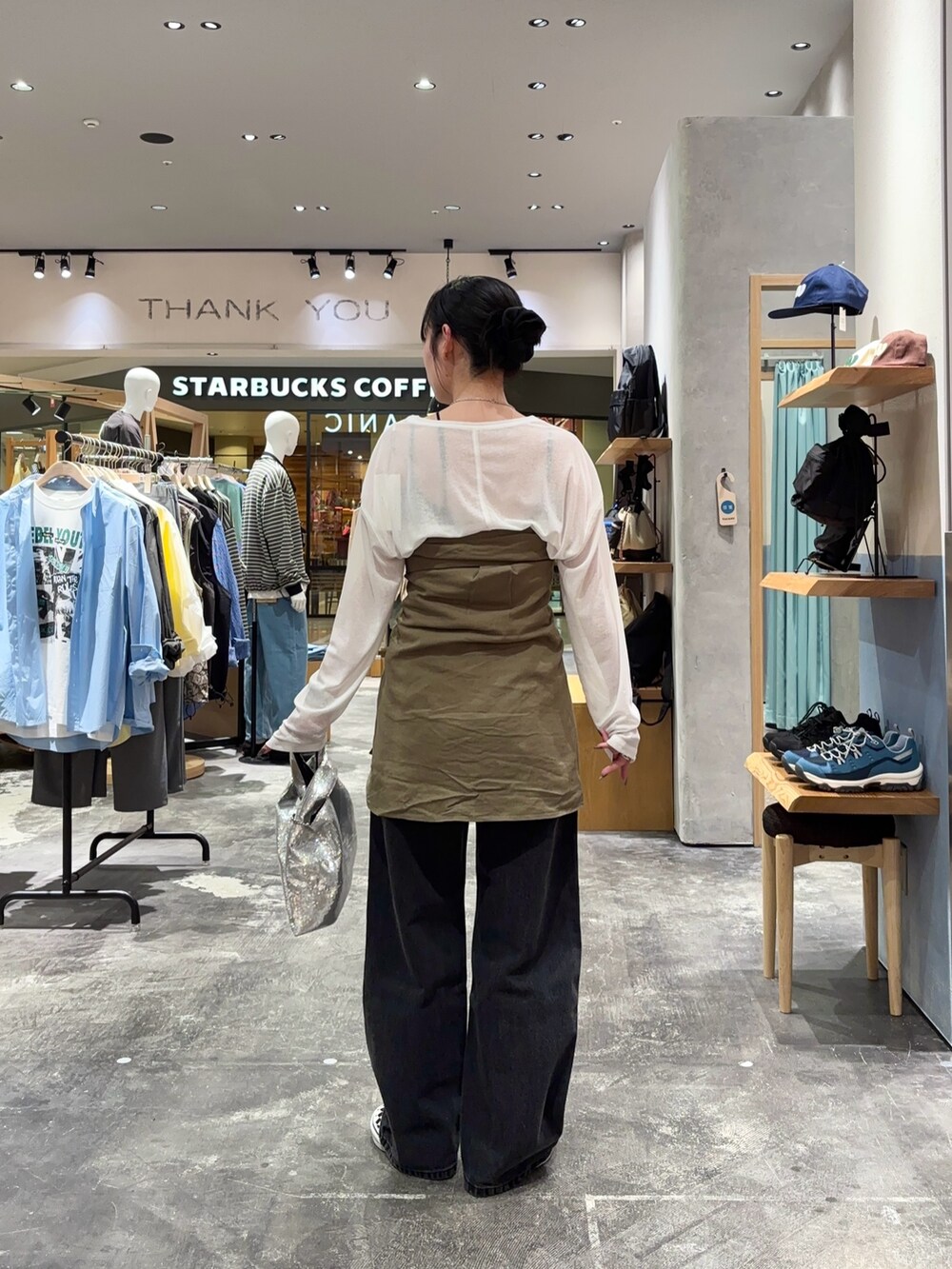 ホワイト系のTシャツ/カットソー、グリーン系のシャツ/ブラウス、ブラック系のデニムパンツを着用したレディースの春コーディネートの3枚目の写真