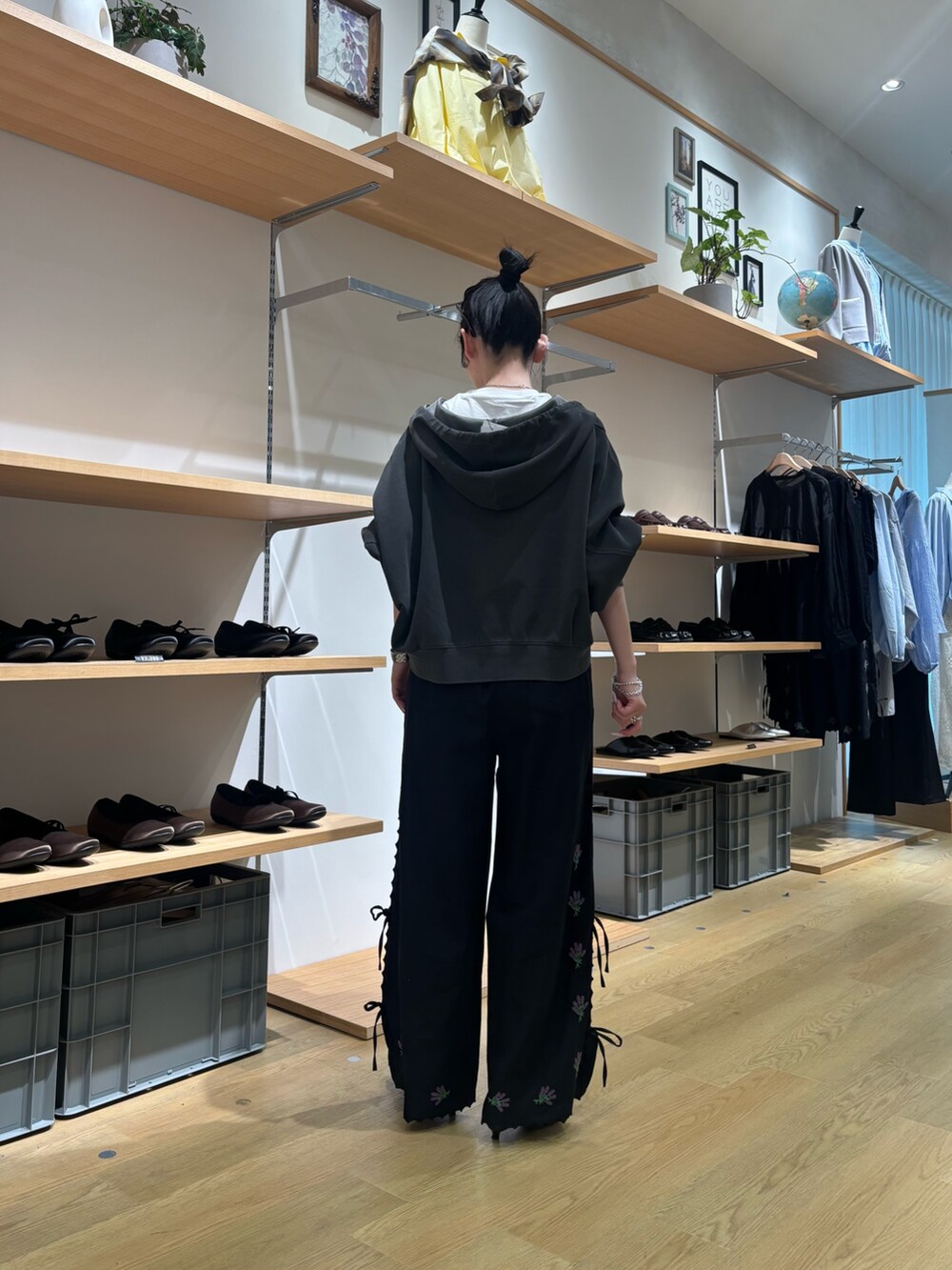 グレー系のパーカー、ブラック系のその他パンツを着用したレディースの春コーディネートの2枚目の写真
