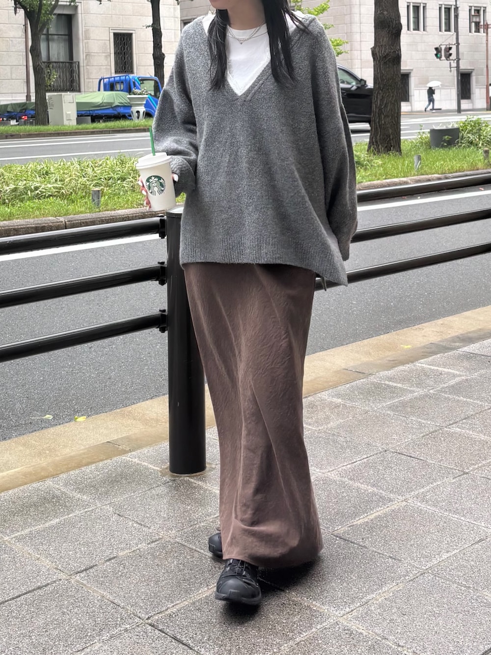 グレー系のニット/セーター、ブラウン系のスカートを着用したレディースの秋コーディネートの2枚目の写真