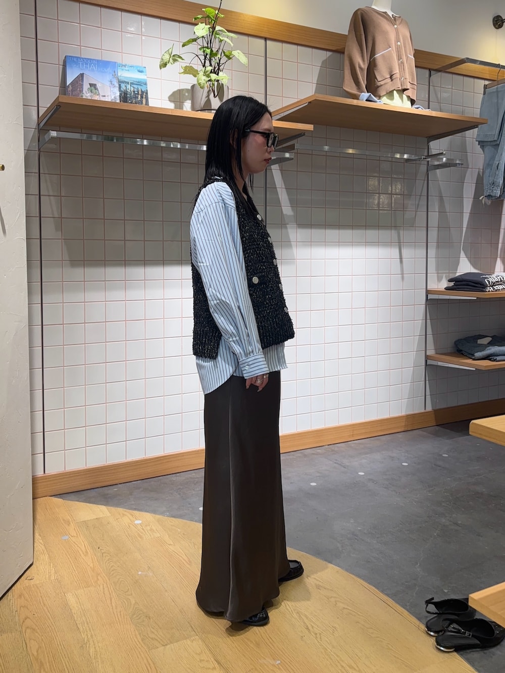 ブルー系のシャツ/ブラウス、ブラック系のベスト、グレー系のスカートを着用したレディースの春コーディネートの3枚目の写真