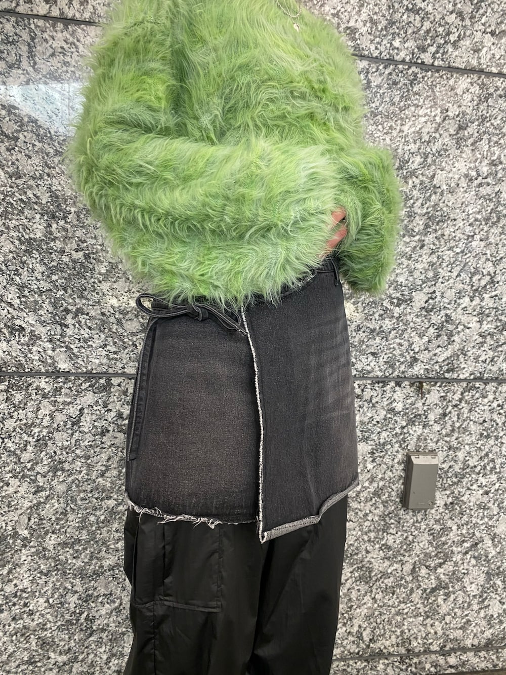 グリーン系のカーディガン/ボレロ、ブラック系のデニムスカート、ブラック系のカーゴパンツを着用したレディースの秋コーディネートの3枚目の写真