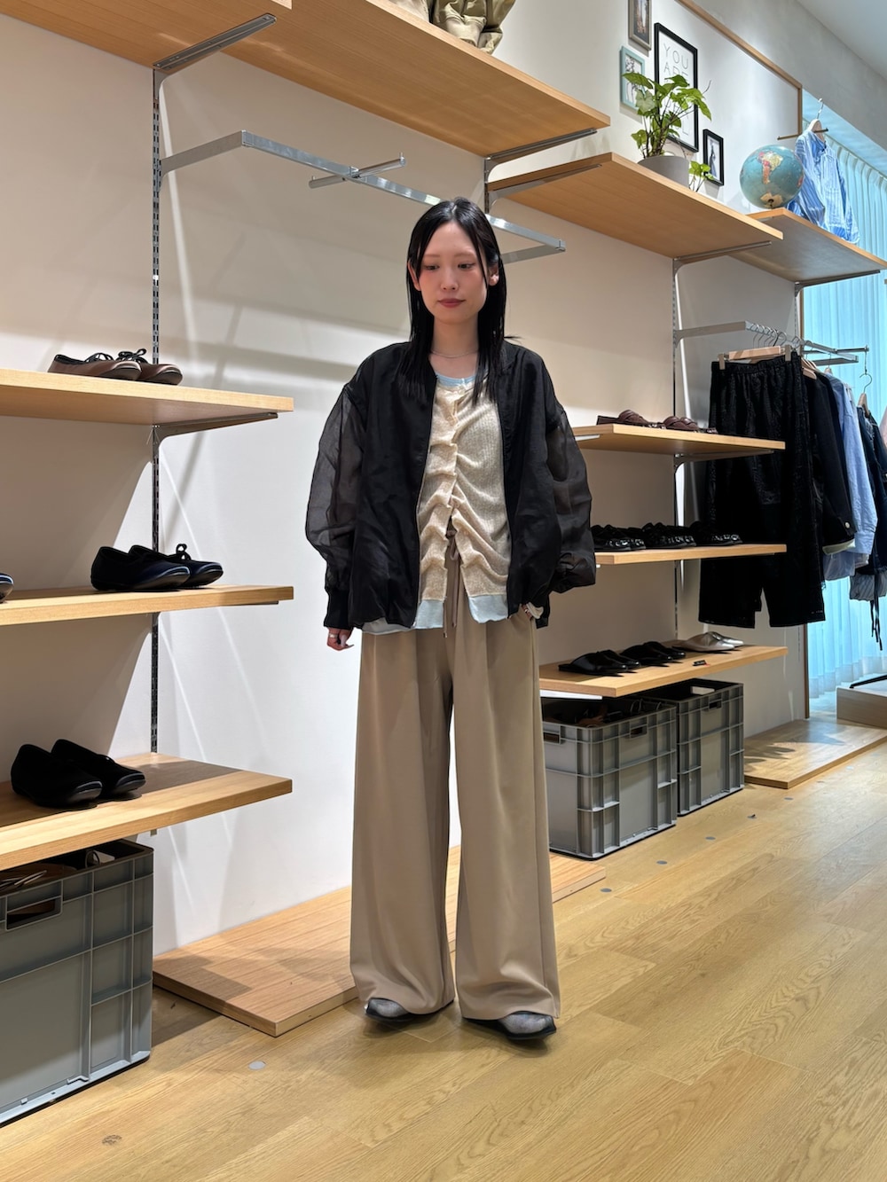 ブラック系のブルゾン、ベージュ系のカーディガン/ボレロ、ベージュ系のスラックスを着用したレディースの春コーディネートの5枚目の写真