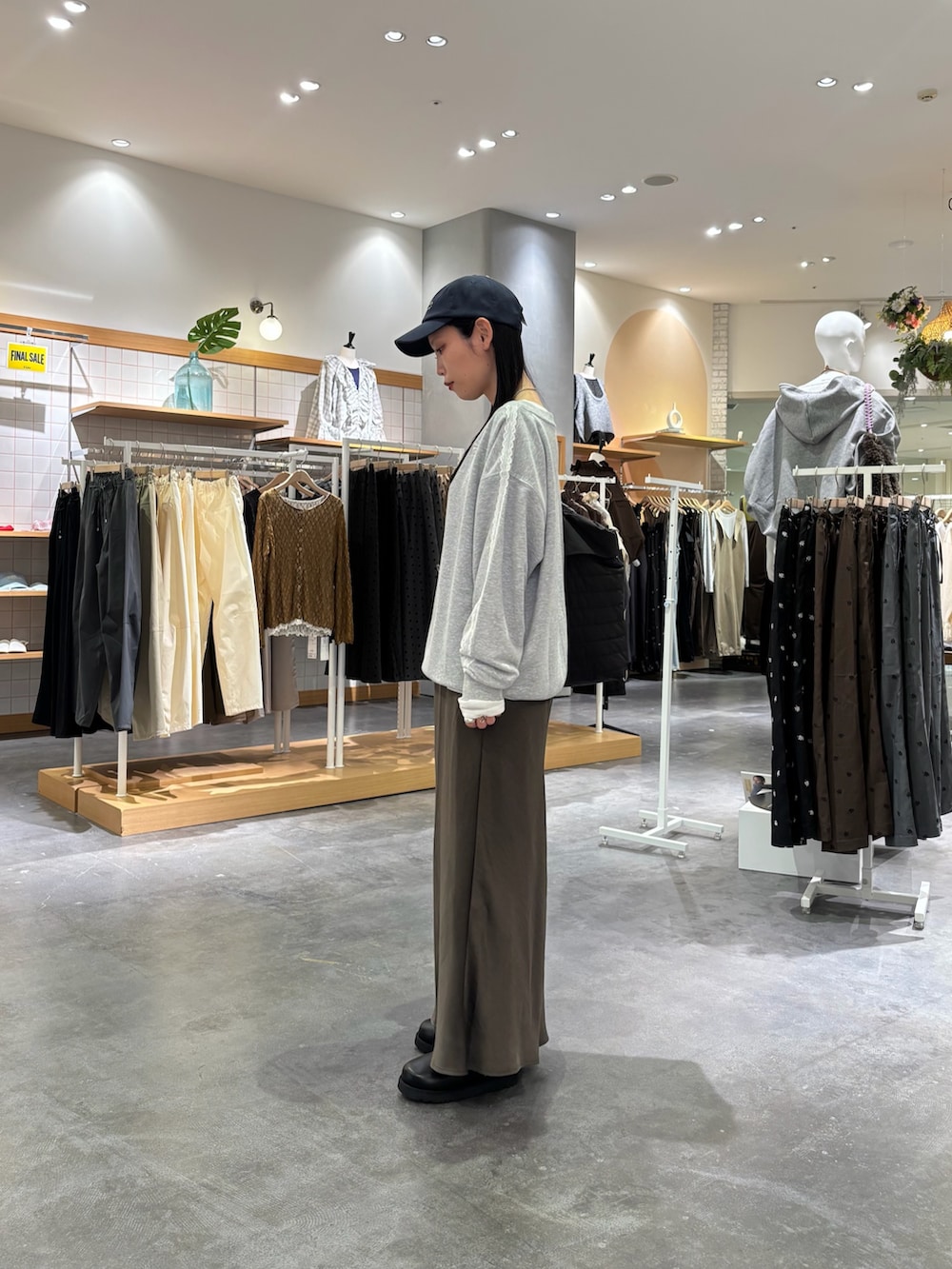 グレー系のスウェット、グレー系のスカート、ホワイト系のTシャツ/カットソーを着用したレディースの秋コーディネートの2枚目の写真