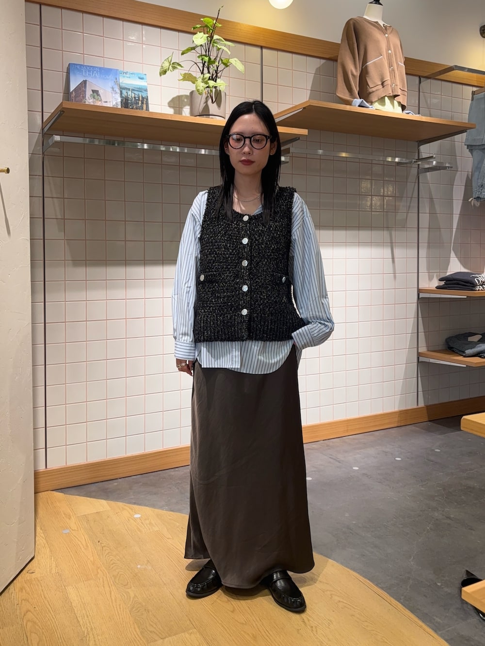 ブルー系のシャツ/ブラウス、ブラック系のベスト、グレー系のスカートを着用したレディースの春コーディネートの6枚目の写真